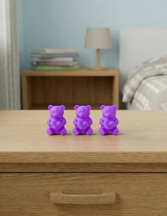 Ositos decorativos de 5 cm con forma de gomita y corazón en el pecho, disponibles en colores vibrantes como rosa mexicano, morado, turquesa, azul,etc. Ideales para colocar sobre estantes, burós o repisas en habitaciones infantiles, como pequeños adornos que aportan un toque divertido, alegre y colorido a la decoración.