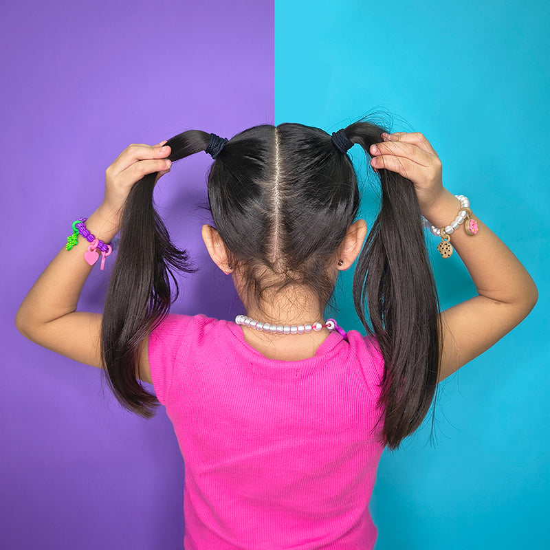 Niña con pulseras coloridas Sanc Kids — joyería infantil con charms intercambiables