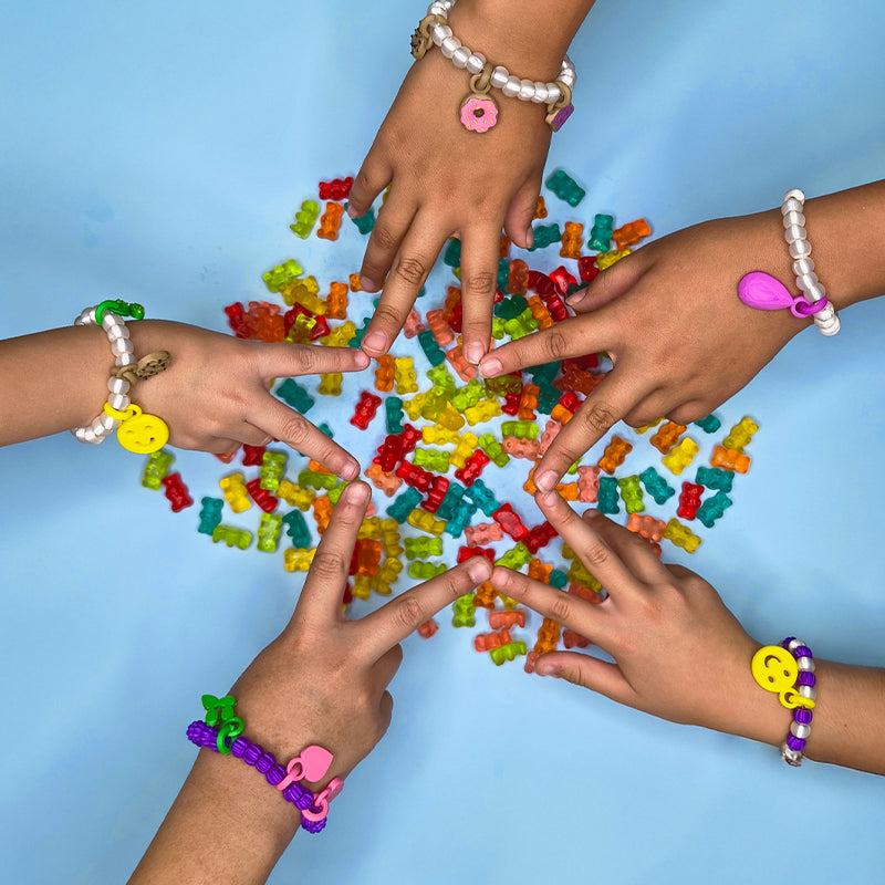Pulseras Sanc Kids con charms — niñas luciendo joyería colorida en ocasiones especiales