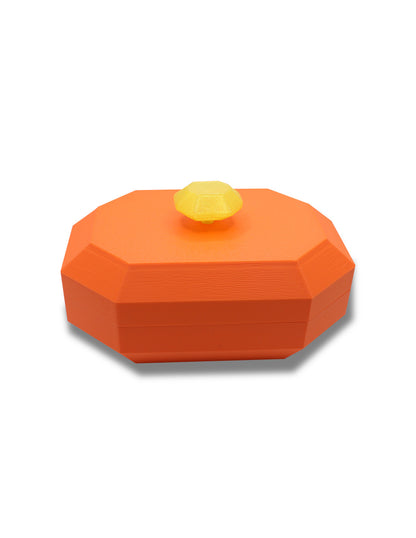 joyero forma octagonal en color naranja y agarradera en forma octagonal amarillo con transparencia que simula una gema en foto vista de frente