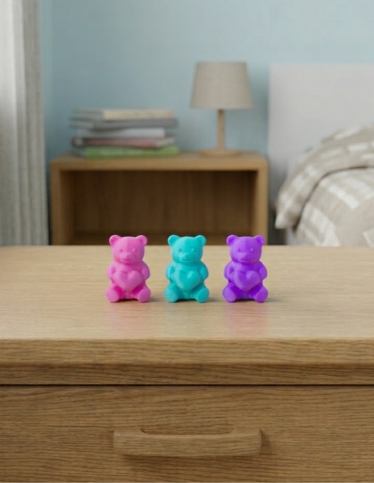 Ositos decorativos de 5 cm con forma de gomita y corazón en el pecho, disponibles en colores vibrantes como rosa mexicano, morado, turquesa, azul,etc. Ideales para colocar sobre estantes, burós o repisas en habitaciones infantiles, como pequeños adornos que aportan un toque divertido, alegre y colorido a la decoración.